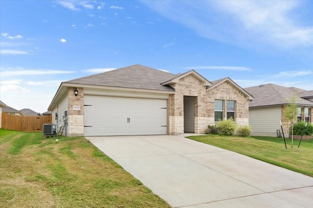 view of front of home featuring central AC unit, a garage, and a front lawn