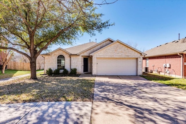 single story home with central AC unit and a garage