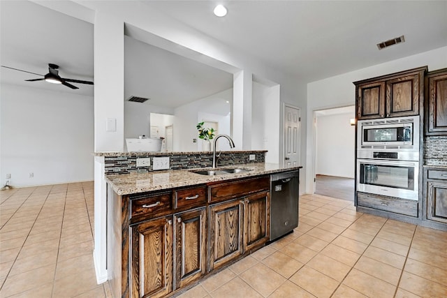 kitchen with ceiling fan, stainless steel appliances, light tile flooring, light stone counters, and sink