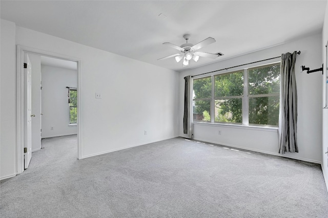 carpeted empty room with plenty of natural light and ceiling fan