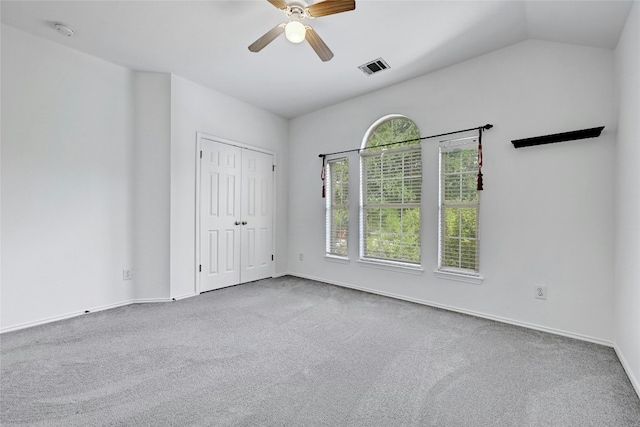 empty room featuring ceiling fan, carpet floors, and lofted ceiling