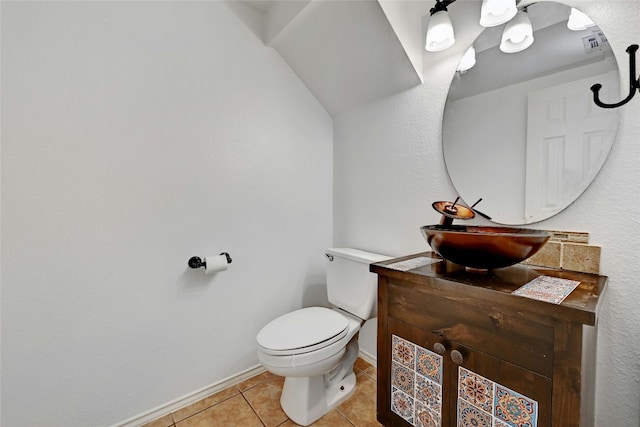 bathroom featuring tile floors, toilet, and vanity with extensive cabinet space