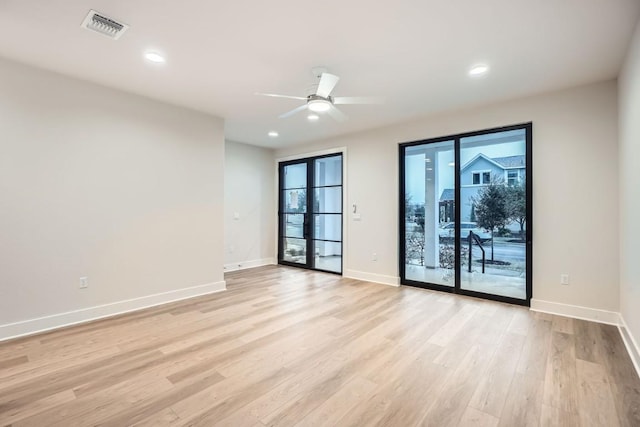 spare room with ceiling fan and light wood-type flooring