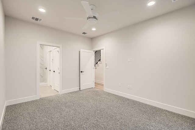 unfurnished bedroom with light colored carpet, ceiling fan, and ensuite bathroom