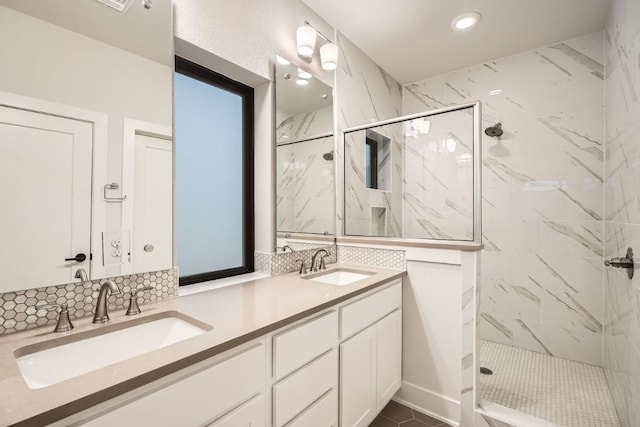 bathroom with tiled shower and vanity