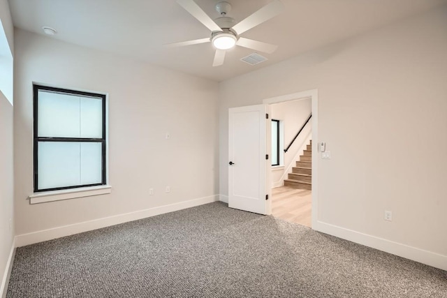 empty room with ceiling fan and light colored carpet