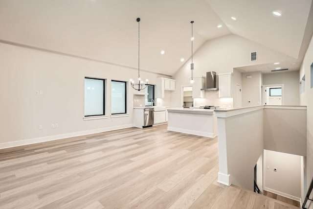 kitchen with wall chimney exhaust hood, hanging light fixtures, stainless steel dishwasher, a kitchen island, and white cabinets