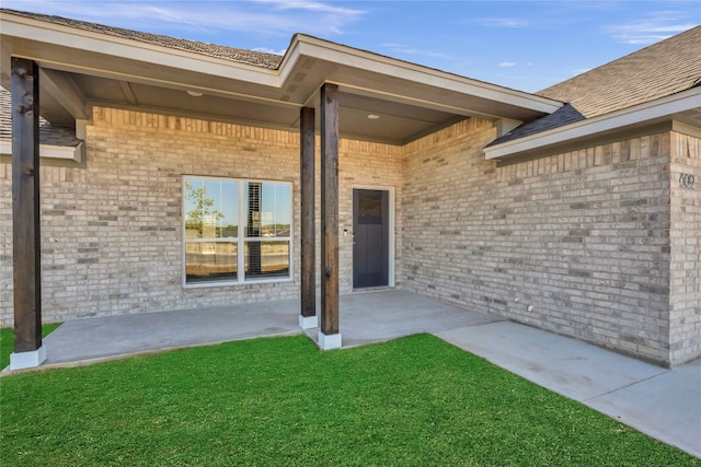 view of exterior entry featuring a yard