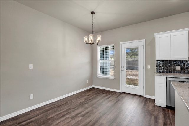 unfurnished dining area featuring a notable chandelier and dark hardwood / wood-style flooring