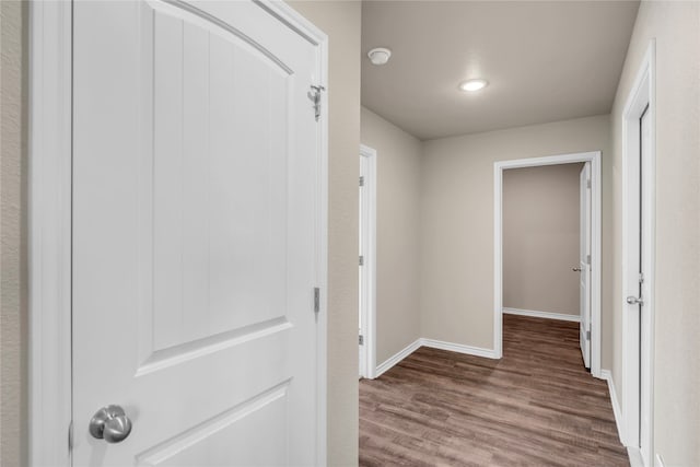 corridor with hardwood / wood-style flooring