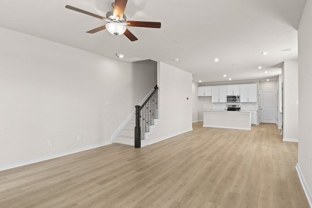 unfurnished living room with light hardwood / wood-style flooring and ceiling fan