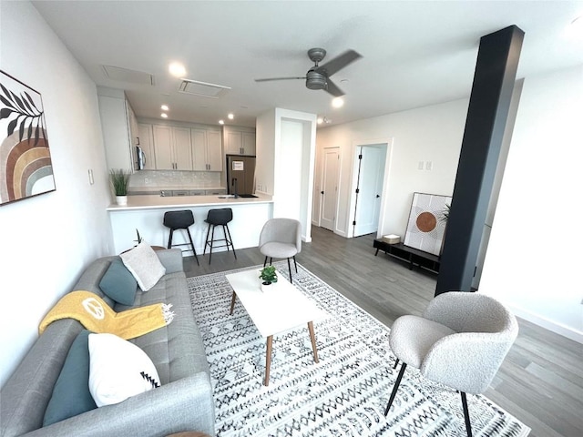 living room featuring ceiling fan and dark hardwood / wood-style flooring