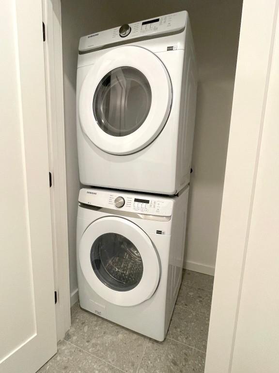 clothes washing area featuring stacked washer / dryer