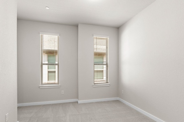 empty room with a wealth of natural light and light carpet