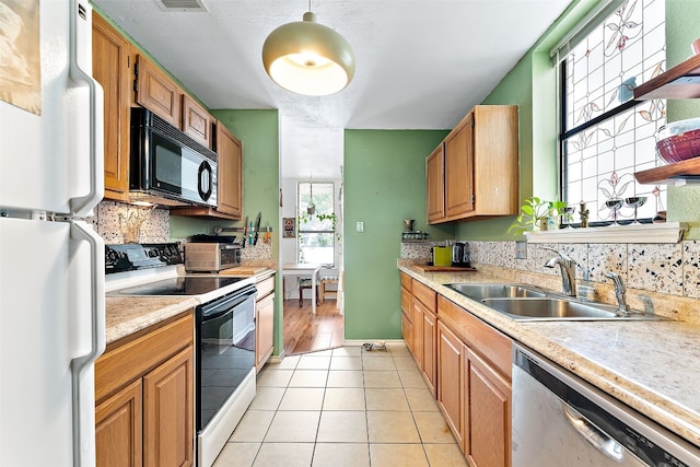 kitchen featuring sink, light tile patterned floors, pendant lighting, and white appliances