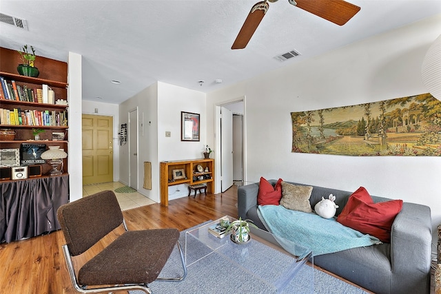 living room with light wood-type flooring and ceiling fan