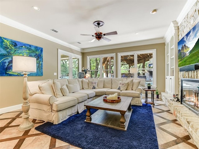 living room featuring a stone fireplace, ceiling fan, built in shelves, and ornamental molding