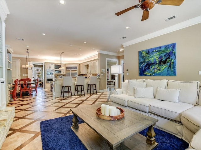 living room with ceiling fan and crown molding