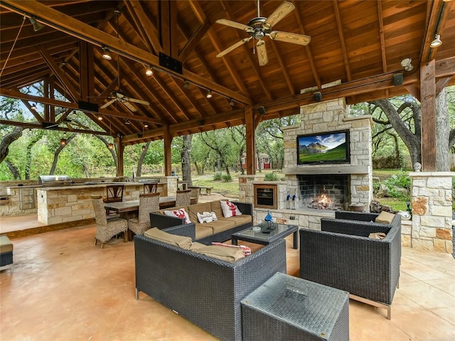 view of patio / terrace featuring a gazebo, ceiling fan, area for grilling, and an outdoor living space with a fireplace