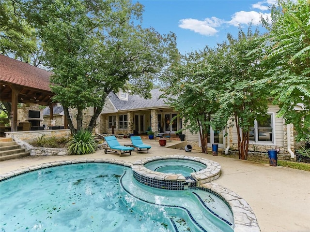 view of swimming pool featuring an in ground hot tub and a patio