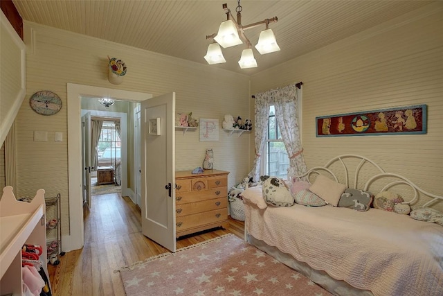 bedroom with a chandelier and light hardwood / wood-style floors