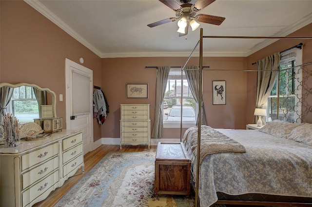 bedroom with ceiling fan, crown molding, and light hardwood / wood-style floors