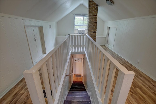 stairs with hardwood / wood-style flooring and lofted ceiling