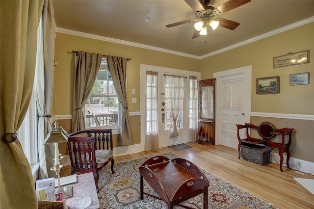 sitting room with ceiling fan, ornamental molding, and hardwood / wood-style flooring