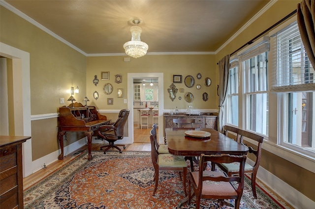 dining area featuring an inviting chandelier, crown molding, and wood-type flooring