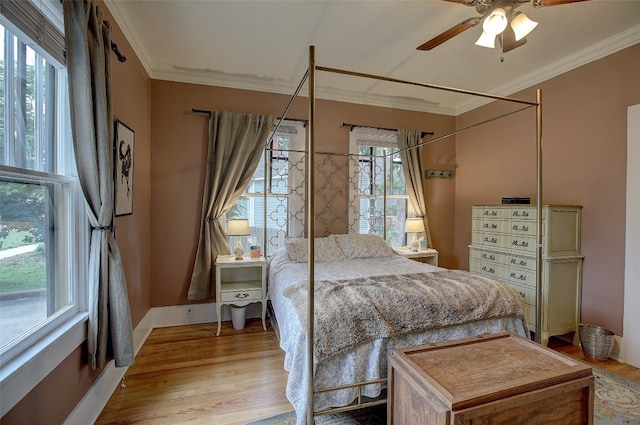 bedroom with light wood-type flooring, ceiling fan, and crown molding