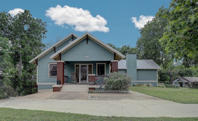 view of front of home featuring covered porch and a front lawn