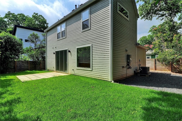 back of property with a patio, fence, central AC, and a yard