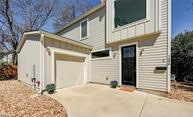 exterior space featuring concrete driveway, board and batten siding, and an attached garage