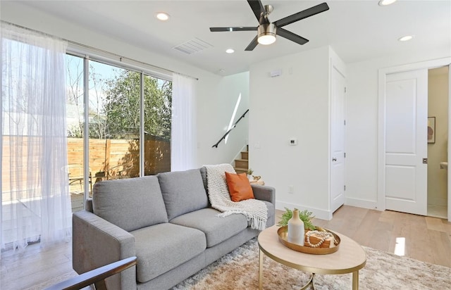 living room with light wood-style flooring, stairs, visible vents, and recessed lighting