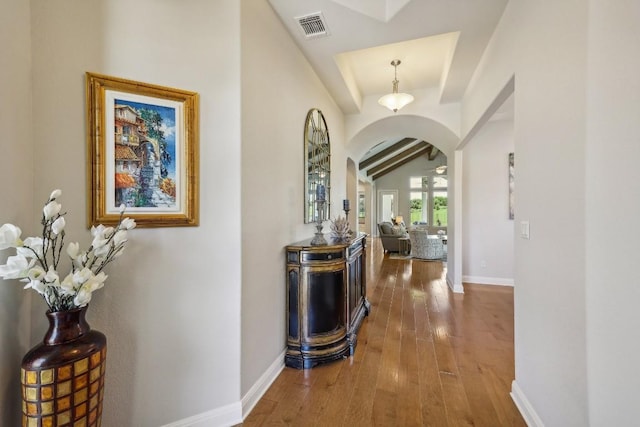 hallway with vaulted ceiling with beams and dark wood-type flooring