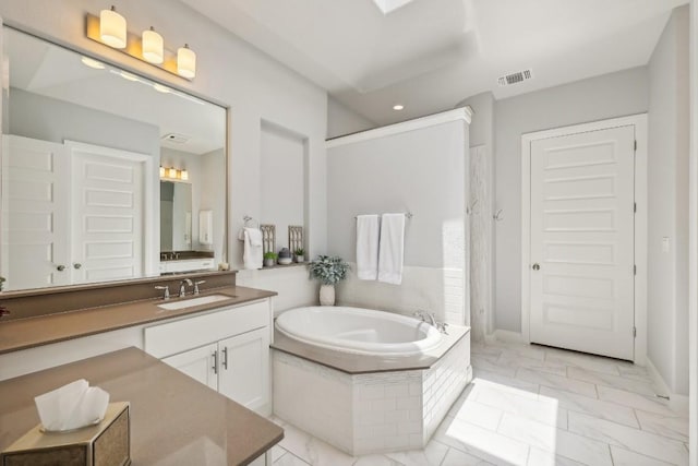 bathroom featuring vanity and a relaxing tiled tub