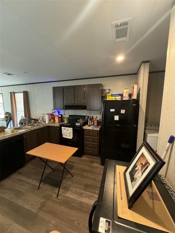 kitchen with dark hardwood / wood-style flooring, black appliances, and dark brown cabinets