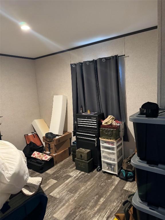 bedroom featuring wood-type flooring and crown molding