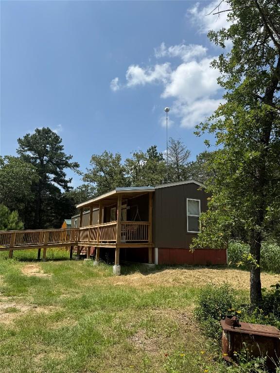 rear view of house featuring a lawn and a wooden deck