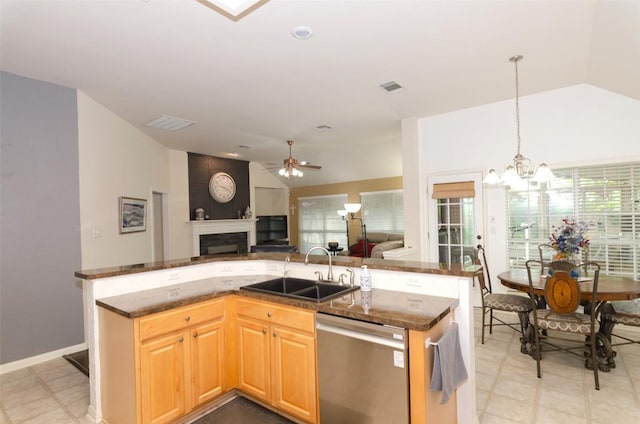 kitchen with lofted ceiling, sink, dishwasher, hanging light fixtures, and an island with sink