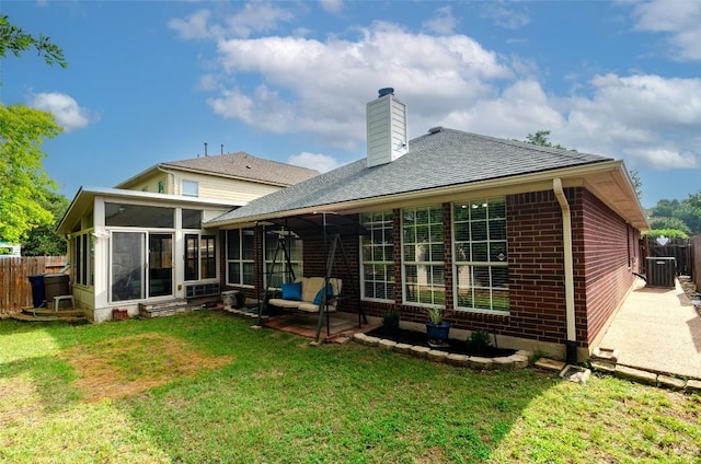 rear view of house featuring a yard, a patio, a sunroom, and central air condition unit