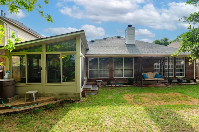 rear view of property with a yard and a sunroom