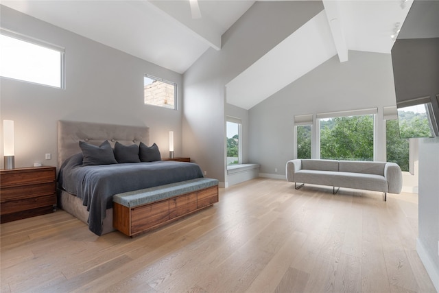 bedroom featuring high vaulted ceiling, multiple windows, and light hardwood / wood-style flooring