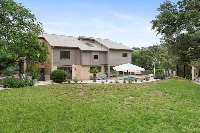 back of house with a patio area and a lawn