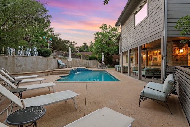 pool at dusk with outdoor lounge area and a patio