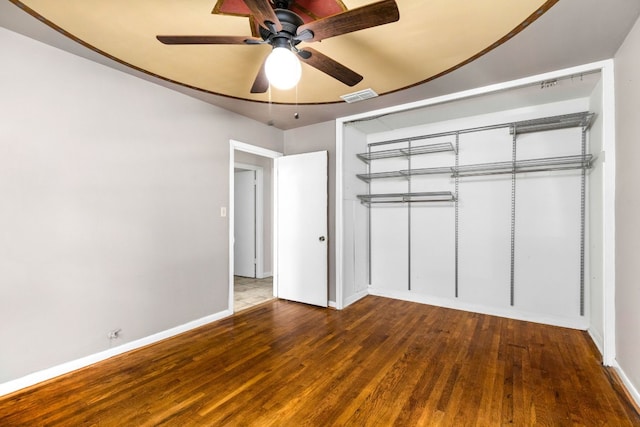 unfurnished bedroom with dark wood-type flooring, ceiling fan, and a closet