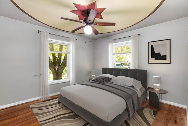 bedroom with dark hardwood / wood-style floors and ceiling fan