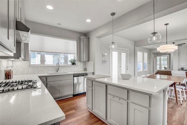 kitchen with sink, a center island, gray cabinetry, and appliances with stainless steel finishes