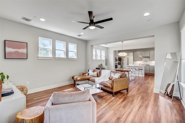 living room featuring light hardwood / wood-style floors and ceiling fan