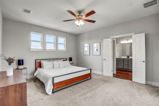 bedroom featuring ceiling fan, connected bathroom, and light carpet